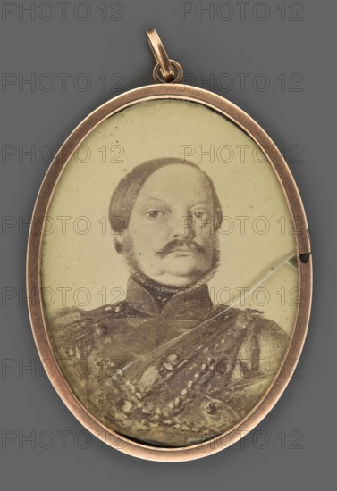 a Portrait of a young nobleman in the uniform of a lieutenant of the National Guard. Bust, slightly right. Short blond hair. White collar, black cravat, navy blue uniform with one epaulet, amaranth collar and lapels, amaranth and silver belt, a sabre hilt visible at the left side. Background stippled, dark blue-green. Binding: smooth copper-bronze rim. b Portrait of the same man at an older age in the uniform of the troops of the Kingdom of Poland. Painted photo, most probably showing the same person; on the reverse a photograph of a man in a military uniform. Dated around 1840–1850. Miniature, height 5.2 cm, width 4.1 cm. Unknown artist; portrait en trois-quarts; male noble portraits; Polish miniature; kontusz coats; military men., An oval pendant with a metallic rim in a warm copper color contains an old sepia-toned portrait of a man with a styled mustache and sideburns, wearing a dark formal uniform with decorative patterns; the portrait shows a visible crack in the surface and some...