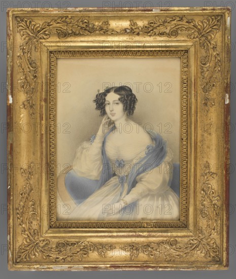 Count Paula de Bellegarde born Volkenstein-Trostburg, Pierre, Claude 1803-1854 painter, aristocracy, three-quarter portrait, flowers, woman, female portrait, dress, hairstyle, foreign miniature, 1840, miniature, height 21.8 cm, width 16.3 cm, A framed portrait of a seated woman shown from the waist up, wearing a pale dress with a sheer overlay and a blue shawl draped over her shoulders; she has dark curled hair styled with small adornments and is posed with one hand touching her face and the other resting on her lap, with a calm facial expression. The portrait is set against a neutral, softly shaded background. The ornate frame surrounding the picture is gold with decorative floral and scroll motifs and shows areas of wear with small spots of underlying colors. Visible colors include gold, blue, pale cream, beige, gray, brown, and touches of darker tones in the hair and shading.