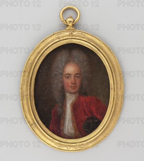 Portrait of a young man, unknown artist, applied wig with curls, frock coat and jabot, waist-length portrait, slightly turned right, young male, foreign miniature, provenance noted repossessed, Jelenia Góra, 3/4 bust right, head almost straight, grey wig parted in the middle lion-style, brown eyes, red justokor with yellow edges, tricorne hat visible under the left hand. Background brown on the left, greenish brown on the right. Convex profiled rim made of gilded bronze frame, dated 1800, miniature; height 6.5 cm, width 5.2 cm., An oval gold-colored frame with decorative raised edging surrounds a small painted portrait of a person. The portrait shows a face with light skin tones and grayish hair, and the figure wears a red garment with a white high-collared shirt visible at the neck. The background inside the frame is dark, and the outer area around the frame is a pale gray. The frame includes a round gold-colored loop at the top.