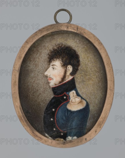 Franciszek Sapalski, lieutenant of infantry artillery, amateur painter; 1810, Poland; miniature, height 5 cm, width 4 cm; inscription: AS role/classification of the creator., An oval miniature portrait in a tarnished metal frame shows a left-facing young man with curly dark brown hair and sideburns, pale skin, and a slight rosy tint to his cheek and lips. He wears a dark blue military-style coat with red trim and small pale buttons, and a cream-colored fringed epaulette on his shoulder. The painted background is mottled with shades of brown, gray, and muted yellow. The frame and hanging loop are metallic with a worn brass or bronze appearance. Colors visible include dark blue, red, cream, brown, gray, pale skin tones, and brass.