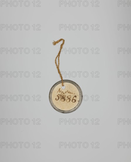 Captain of the 2nd Line Infantry Regiment, Kurowski, Józef Szymon 1809–1851 painter, Poland, 1831, miniature, height 5.2 cm, width 4.7 cm, A small round tag with a metal rim hangs from a twisted piece of coarse brown twine against a pale gray background; the tag's central disk is an aged, off-white or beige color with darker brown markings on its surface.