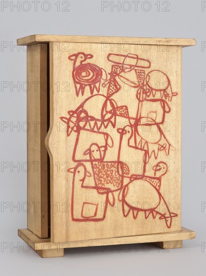 Single-door wardrobe with painted decoration covering the outer surface of the door — composition presenting a silhouetted flock of sheep with a shepherd figures overlap, creating a graphic ornament. 1947–1948. Zakopane. Toy. Wood. Height 22 cm; width 17 cm; depth 7 cm. Maker: Kenar, Antoni 1906–1959, sculptor. Co-creators: State Secondary School of Fine Arts in Zakopane; Office of Production Aesthetics Supervision Warsaw, 1947–1949., A wooden box with a sliding front panel stands on a small base; the wood is light tan to pale brown and shows a smooth, slightly grainy surface, and the box has simple rectangular edges and a carved finger notch on the sliding panel. Drawn across the front panel in a reddish color is a continuous, playful line illustration of a group of roughly outlined animal-like figures with rounded bodies, stick legs, simple heads, and decorative patterns; the red drawing features spiral shapes, scalloped or triangular teeth-like marks, and looped lines connecting the...