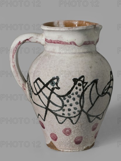 Jug with a handle with zoomorphic decoration: procession of hens; made 1949 by Antoni Kenar 1906–1959, sculptor; co-creators: Office of Production Aesthetics Supervision Warsaw; 1947–1949 and State Secondary School of Fine Arts in Zakopane Zakopane; est. 1876; materials: ceramics; features: zoomorphic representations, linear patterns, painted decorations; unique item; vessel; place of origin: Zakopane; dimensions: height 18.5 cm, width 13.8 cm, depth 16.0 cm., A ceramic pitcher with a rounded body, a curved handle, and a spout, shown against a plain gray background; the exterior glaze is primarily off-white or cream with visible crackling and a glossy brown interior around the rim; decorative painted motifs wrap around the body in dark green or black lines forming abstract bird-like shapes and dotted patterns, with a band of reddish-pink near the neck and several reddish-pink circular spots near the base; areas of wear and small surface pits reveal a tan or light brown clay beneath.