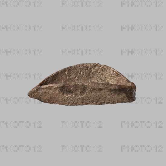 Eye setting, small, from a child's sarcophagus mask or a figurine's face; boat-shaped; ca. 1550–332 BC New Kingdom–Late Period, Egypt; sarcophagus mask, or sculpture ; height 3 cm; creator, possible sarcophagus fragments; eyes, masks, faces., A roughly crescent-shaped textured object sits centered against a flat neutral gray background; the object has a coarse, granular surface with metallic sheen in shades of brown and bronze, with darker brown areas and subtle golden highlights, and its edges are irregular and slightly jagged.