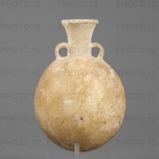 Flask-shaped vessel, pilgrim flask with a spherical, flattened belly, narrow high widening neck and three small ring-shaped handles; stone; ca. 1550–1186 BC, New Kingdom, 18th–19th Dynasty, Egypt; height 8.8 cm, width 6.1 cm, weight 0.15 kg., A rounded vessel with a narrow neck and a flared rim, featuring a pair of small loop handles at the shoulder; the surface shows an uneven, worn texture with scratches and small dark spots. The colors visible are beige, cream, off-white, and light tan, set against a solid medium-gray background.