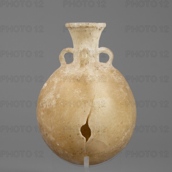 Flask-shaped vessel, stone, pilgrim flask with a spherical flattened belly, narrow widening high neck and three small ring-shaped handles; ca. 1550–1186 BC, New Kingdom, 18th–19th Dynasty, Egypt; height 8.8 cm, width 6.1 cm, weight 0.15 kg, A rounded vessel with a narrow flared neck and a pair of small looped handles where the neck meets the shoulder sits against a plain gray background; the vessel is mainly beige to light tan with areas of off-white and slightly darker brown discoloration, a vertical crack runs from the neck down through the body to a jagged hole near the lower center, and the surface shows a worn, slightly rough texture with small pits and patches of lighter residue.