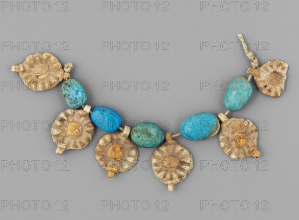 Fragment of a necklace - rosettes and flat beads, Goluchów Greater Poland Voivodeship; rosettes, necklaces, beads, grave goods; 6 white rosettes with a yellow center and 5 blue beads; ca. 1550–1295 BC; New Kingdom, 18th Dynasty, Egypt; amulet, jewelry, A necklace segment laid on a neutral gray background consisting of a string with a group of round, fluted disk-shaped beads in beige, tan, and off-white tones alternating with a few irregular oval beads in bright turquoise and teal blue, with small cylindrical spacer beads in light beige; the disk beads show surface variations and spots of darker brown and yellowish-orange, and the turquoise beads show mottled darker speckles; a short knotted cord in natural beige is visible at one end.