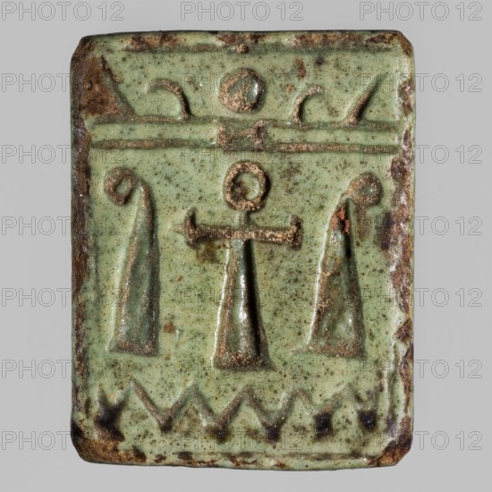 Amulet plaque with the head of the goddess Hathor;, Hathor myth, Egyptian deity; plaque amulet with ankh iconography; ca. 1295–1069 BC, New Kingdom, 19th–20th Dynasty, Egypt; height 2.2 cm, width 1.8 cm, A rectangular object with rounded corners, mostly pale green with darker green and brown mottling, shows a raised symmetrical design: a central vertical element topped by a circular form and a horizontal bar, flanked by two elongated tapered shapes with curled tops; above these is a horizontal band with small raised shapes and below is a zigzag border with darker brown accents; the edges show worn brown areas and slight surface pitting.