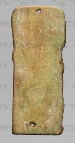 Amulet - plaque in the shape of the god Imseti, Relief figurine of the god Imseti, shown in right profile, in the form of a mummy with a human head in a wig and a divine beard. In front of the god's figure is an ostrich feather on a banner, connected to the god's body by a piece of decorative material. A mat under the feet. Presumably an element of a mummy net. Egyptian deities; Sons of Horus mythology; Imseti mythology. 664–525 BC; Late Period, 26th Dynasty, Egypt. Amulet; height 6.1 cm; width 2.6 cm., A vertically oriented, narrow rectangular object with rounded corners and a slightly irregular, wavy outline, showing a weathered, rough surface in shades of green, brown, tan, and pale white; there are two small circular holes, one near the top edge and one near the bottom edge, and scattered areas of darker brown and rust-colored spots with lighter pale flecks and scratches across the surface.