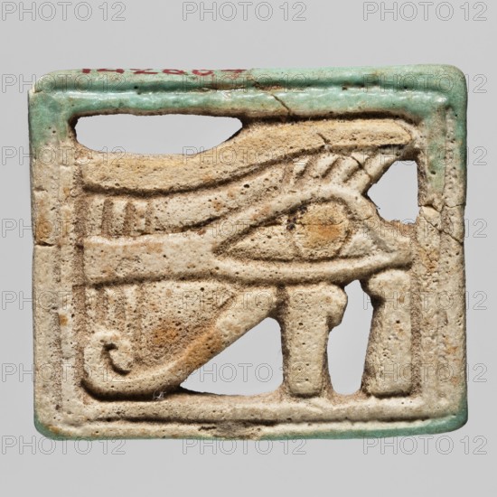 Amulet - udjat eye, udjat eyes, grave goods, Egyptian religion, ca. 945–656 BC; Third Intermediate Period, 22nd–25th Dynasty, Egypt, amulet, height 3.2 cm, width 3.8 cm, A rectangular carved object with rounded corners showing a stylized eye motif in relief, made of a porous beige material with areas of darker brown discoloration and surface texture; the top and bottom edges have traces of green-blue glaze, and there are small flecks of red near the top edge; the background behind and through some carved openings appears light gray.