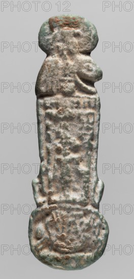 Amulet — counterweight menite;, Sekhmet mythology with solar disk iconography; grave goods; Egyptian deities; 664–525 BC, Late Period, 26th Dynasty, Egypt; amulet; height 7.7 cm, width 2.5 cm, An elongated, weathered object with an irregular, rounded top and bottom, showing a textured, pitted surface and worn raised areas that suggest carved or cast details; the surface displays a mix of muted green, pale beige, gray, and hints of brown, with patches of darker discoloration and lighter, almost whitish highlights; the form tapers slightly in the middle and has a rectangular central panel with indistinct, uneven relief, flanked by subtle protrusions and shallow grooves, while the lower rounded end contains a more concentrated area of raised, circular shapes and depressions.