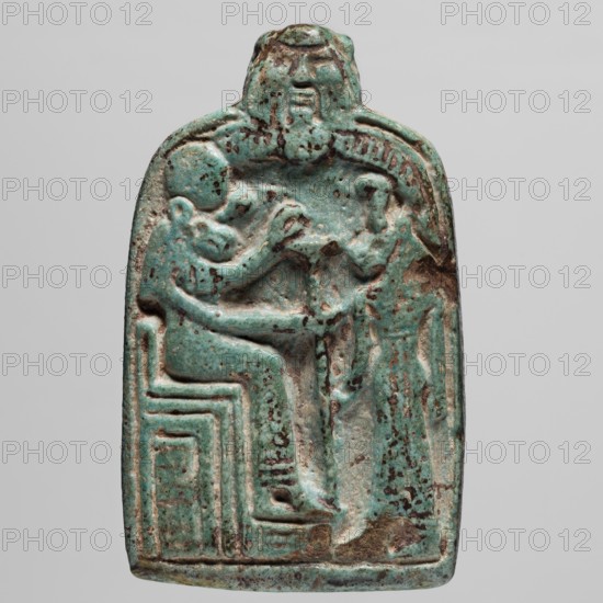 Amulet — stele with lion-headed goddesses Bastet and Sekhmet?, lionesses, Egyptian deities; possibly Sekhmet, Bastet, Bes; thrones; ca. 747–525 BC 25th–26th Dynasty, Egypt; amulet; height 7.1 cm, width 4.6 cm., A carved rectangular amulet with rounded top showing a raised relief of a seated human figure facing a standing smaller figure, both rendered in shallow relief; the seated figure sits on a blocky, stepped seat while the standing figure reaches toward the seated figure; above them a larger head or mask-like form overlooks the scene; the surface shows a weathered, speckled patina in shades of turquoise and green with areas of darker brown and black spotting and some lighter worn patches; the background around the figures is slightly recessed and the edges of the object are smoothed and irregular.