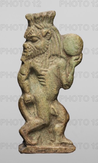 Amulet - dancing god Bes, Bes mythology. Figurine of Bes shown in right half-profile, head turned back; holds a tambourine in his left hand, right hand grasps base of his tail; four feathers on his head. Greenish faience. c. 1550–c. 1069 BC; New Kingdom, Egypt. Amulet; height 4.6 cm, width 2.1 cm., A small carved figure with a greenish-brown surface stands against a plain light-gray background, depicted in profile facing left with a pronounced beard and textured hair topped by a flat crown-like element, a rounded object held near its shoulder by a raised arm, a stocky torso with carved ribs and muscular limbs bent at the knees, and a narrow rectangular base beneath its feet; the surface shows mottled areas of muted green, brown, and tan.