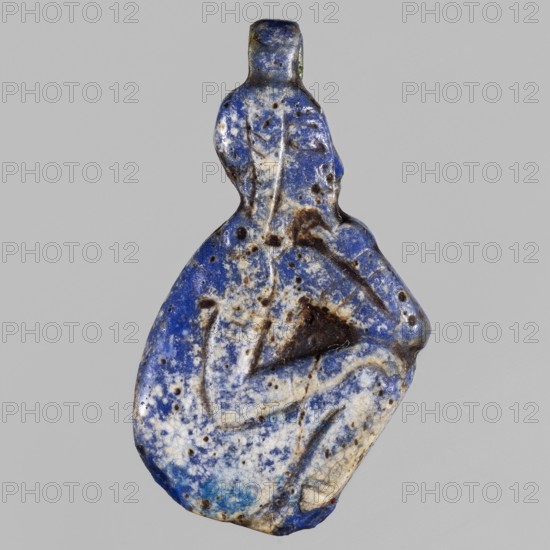 Amulet - god Horus-child; maker, figure with tucked legs and a finger to the mouth; Horus myth., Egyptian deities, Egyptian religion; ca. 1550–1295 BC, New Kingdom, 18th Dynasty, Egypt; amulet; height 2.9 cm, width 1.5 cm, A small, irregularly shaped carved object with a worn, textured surface showing a mix of deep blue, pale blue, white, brown, and black tones; the form suggests a rounded lower portion tapering to a narrower upper section with a small loop or protrusion at the top; surface shows pitting, speckling, and areas of discoloration with darker patches and lighter veins, and shallow incised lines create subtle contours and shapes across the piece.