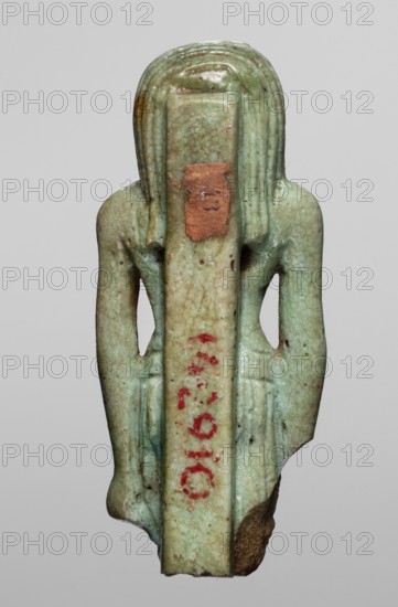 Amulet — god Thoth; maker, Thoth myth., Egyptian deities, Egyptian religion; Egypt, 664–525 BC Late Period, 26th Dynasty; amulet; height 5.2 cm, width 2.1 cm, A small carved figure viewed from the back, rendered in a pale green glazed material with a slightly mottled surface and areas of darker green and brown discoloration; the figure has long vertical hair or a headdress that falls along the back and sides, with carved ridges and gentle rounded contours; the shoulders are broad and the arms are close to the body, creating narrow open spaces at the sides; there are traces of reddish pigment on the central vertical back strip and a small patch of brown material adhered near the upper back; the lower edge shows a rougher, unglazed brown area and the overall surface has small pitted marks and worn spots.