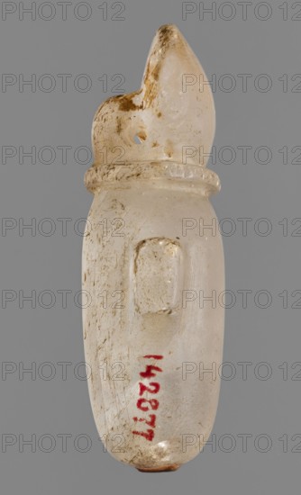 Amulet — heart with a sun disc;, Goluchów Greater Poland Voivodeship; heart with sun disc iconography; grave good protective amulet; 664–332 BC, Late Period, Egypt; amulet; height 5 cm, width 2.5 cm, depth 1.5 cm., A small elongated object with a smooth, slightly translucent surface in off-white and beige tones, showing areas of darker brown discoloration and wear; it has a rounded top that tapers to a point and a circular hole near the upper portion, a raised ring around its neck, and a small raised rectangular protrusion on one side; the surface shows scratches and scuffs and a small patch of reddish color near the lower area, set against a plain gray background.