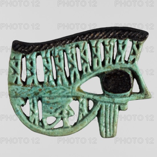 Amulet - udjat eye, udjat eyes, grave goods; Egyptian religion; depiction of 12 baboons with a small eye; ca. 945–656 BC, Third Intermediate Period, 22nd–25th Dynasty, Egypt; amulet; height 4.1 cm, width 5.2 cm;, A carved object shaped like an eye rendered in a turquoise-green material with a dark, nearly black oval at the center where the pupil would be, featuring a textured dark top edge and a series of vertical cutouts and raised ridges throughout the body creating a lacy, openwork pattern, with visible areas of lighter and darker green mottling and small brownish spots.