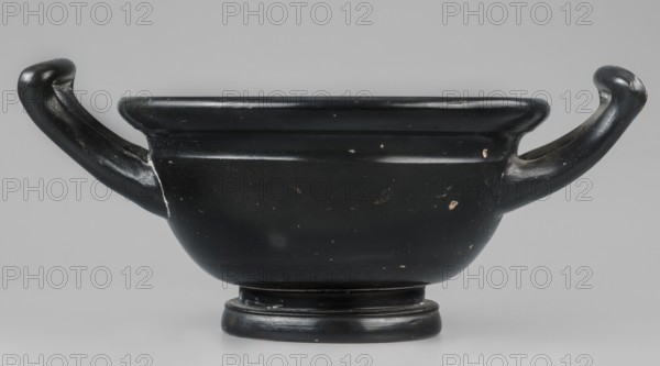 Black-finned skyphos, Czara-skyphos of the thick-walled variety with two handles, with a deep bowl on a low, profiled foot. Inside the vessel is an ornament made with a stamp, with six palmettes. Inside the circle are two concentric circles, between which are placed ovules. The whole is surrounded by a band of ovules between two engraved lines. The outer part of the vessel's foot is decorated with concentric circular elements. Technology: Varnish evenly distributed, matte. Visible turning marks. Admixtures: mica pyroxene. Clay color 2.5 YR 6/6 light red. Varnish color 10 YR 2/1 black. Attributed to Kamila Nocon, early 4th century BC, Attica place of manufacture. Vessel skyphos. Dimensions: height 10.4 cm, width 23.5 cm, depth 16.6 cm, weight 0.456 kg, foot diameter 8.2 cm., A black ceramic vessel with a rounded bowl-like body set on a short pedestal base and a broad rim, featuring a pair of curved handles that extend outward and upward from opposite sides; the surface shows small areas...