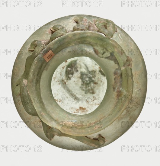 Bottle, unknown eastern workshop, Goluchów Greater Poland Voivodeship, 3rd century, vessel, height 7 cm, width 8.5 cm, A round translucent object viewed from above with a wide circular opening, showing a smooth inner surface and a border with raised, curved decorative elements; the object displays a palette of green and pale green with patches of brownish and pinkish discoloration and some areas of iridescent sheen, and the interior shows mottled pale green and brown tones.
