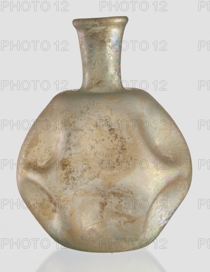 Flask, unknown eastern workshop, Goluchów Greater Poland Voivodeship, 3rd–4th century AD, vessel, height 11 cm, An iridescent glass vessel with a flattened, rounded body and a short, narrow neck, showing a textured surface with a mix of muted gold, beige, pale green, and subtle pink and blue highlights, and areas of darker mottled staining and lighter worn spots.