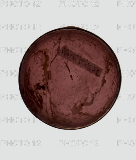 Bottle, unknown eastern workshop, Goluchów Greater Poland Voivodeship, 3rd century, vessel, height 4 cm, width 3.4 cm, A round, shallow dish viewed from above with a smooth, worn interior surface showing mottled areas and irregular stains; the dominant color inside the dish is deep reddish-brown with darker brown patches and some glossy, slightly lighter brown streaks, and the rim appears dark brown to nearly black against a pale gray background.