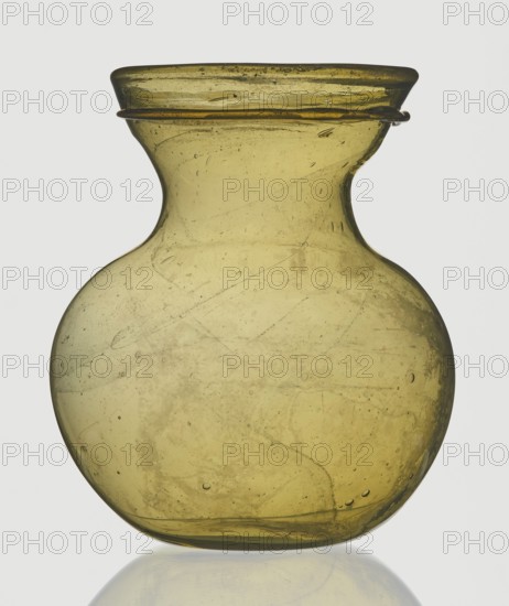 A viceless vessel, unknown,  author, Goluchów Greater Poland Voivodeship, Below the edge a glass thread is applied horizontally., unspecified, vessel, height 12.4 cm, width 10.7 cm, A translucent olive-green glass vessel with a rounded body that tapers to a narrower neck and flares out at the rim, showing internal bubbles and streaks within the glass and a small ring of glass around the rim, photographed against a pale neutral background with a subtle reflection beneath; visible colors include olive-green, darker greenish-brown areas, and the pale gray of the background.