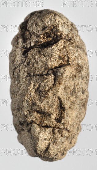 Cuneiform tablet with receipt, unknown Babylonian official role classification of creator, cuneiform tablets, Neo-Babylonian document, trade, Eastern Gallic Scenography, Rectangular tablet, slightly convex, horizontally oriented. Three corners broken off; cracks on the lower and left sides; 9 lines of cuneiform text on the obverse, 2 on the lower side, 9 on the reverse. 6th century BC; Neo-Babylonian period, Babylonia Iraq, Southern Mesopotamia, administrative document, height 3.8 cm, width 4.5 cm, thickness 2 cm, A roughly oval-shaped, irregular textured object fills the frame, showing a surface of rough, cracked, and pitted material in shades of beige, tan, brown, and gray with areas of darker brown in crevices; the background is a smooth pale gray.