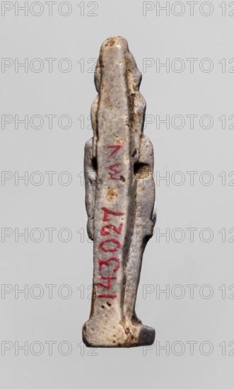 Amulet - god Horus; double crown on the head; Egyptian deity depiction; material/technique: amulet; iconography: double crown; date: 664–332 BC Late Period, Egypt; dimensions: height 3.8 cm, width 0.8 cm., A small vertical figurine-like object stands against a plain light gray background, showing a worn surface with a mix of light gray, off-white, beige, and brown discoloration; the object has an elongated central body with rounded protrusions on the sides and a slightly wider base, and there are traces of red pigment on the front surface.