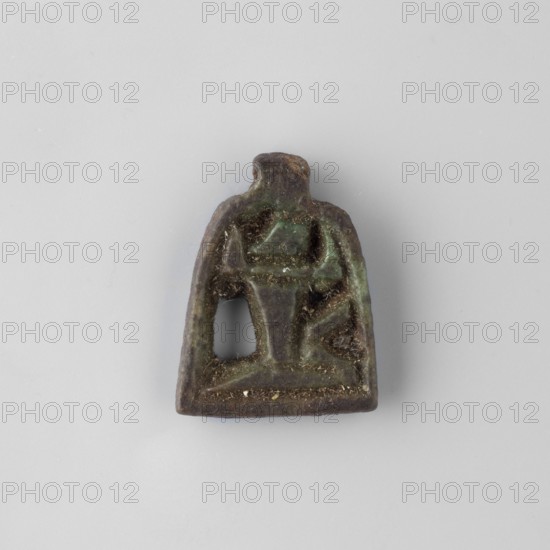 Amulet – plaque with the god Heh; unknown creator; Shu mythology. Openwork plaque showing the god Heh depicted in a very schematic manner. The palm stems held by the figure form a kind of frame with a pendant. 664–332 BC Late Period, Egypt. Amulet; height 1.9 cm, width 1.4 cm, depth 1.8 cm., A small worn object with an irregular trapezoidal outline and a rounded top, showing a raised central motif and a hollowed opening on one side, sitting on a plain light gray background; the object displays mottled dark brown and green tones with areas of lighter green patina and small specks of beige debris.