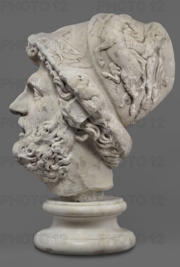 Head of Menelaus from the Menelaus Carrying the Body of Patroclus group, unknown artist. Head of a bearded man wearing a helmet, with an expressive face shown by wide-open eyes and parted mouth, emphasized by chiaroscuro effects from lush locks of beard and hair emerging from under the helmet contrasted with smooth facial skin—the face of a man experiencing dramatic moments. The helmet is adorned with relief decoration depicting fantastic creatures: on each side a centaur fighting a Greek, and below on the edge a triton figurine. The sculpture is a Roman copy of the head from a Hellenistic bronze composition depicting Menelaus carrying the body of Patroclus. Menelaus, Helen's husband, first fights to retrieve the deceased's body and then carries it from the battlefield for burial. The death of Patroclus, Achilles' friend, is a pivotal moment in the Trojan War, prompting Achilles' return to battle. Theme frequently reproduced in Roman sculpture; dated to the 1st half of the 2nd century ...