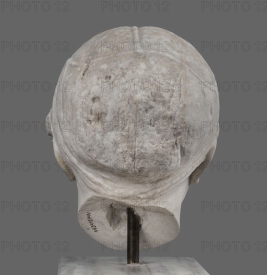Head of Sappho Head of a Woman of the Kora Albani type, unknown Roman workshop. Sappho ca. 610–580 BC, female portrait, Roman sculpture. Fragment of an ancient dowry or bust mounted on a modern bust. Numerous modern additions to details e.g., tip of the nose. The ancient part very good workmanship was originally part of a statue or bust herm?. Head slightly turned to the right, oval, idealised face. Hair covered with a headnet kekryphalos. The sculpture's original is identified as contemporary to Phidias; dating is possible based on analogy to one of the Parthenon friezes. Type belongs to the Sappho/Kora Albani group, preserved nearly intact. Front is very well-crafted; back is simplified and somewhat underdeveloped. This copy has several minor details altered compared to the original. Early 1st century, Roman Empire 27 BC–476, sculpture, weight 30.5 kg., A weathered stone sculpture of the back of a head displayed on a metal rod and square base, showing textured surface variations and ...