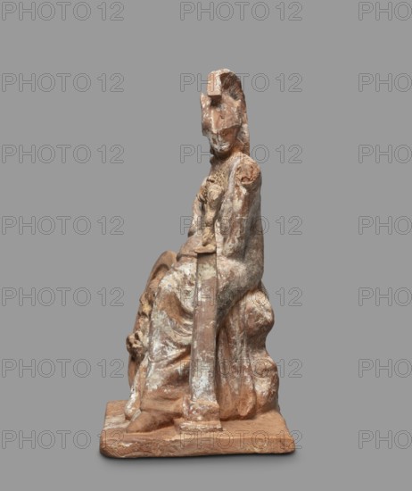 Athena figurine, Classical Gallic scenography, depicting Athena and Nike; 4th century BC, Greece; figurine; height 16.5 cm, width 13.5 cm, depth 7.8 cm, weight 0.35 kg., A weathered seated statue rendered in earthy tones of brown, beige, and pale off-white, showing a robed figure with a headpiece and a calm, worn face; the figure's drapery falls in folds over the seated form, with a long vertical element extending downward from the torso, and the base and surrounding areas show textured, rough surfaces and patches of lighter residue; overall the object displays a mottled mix of brown and pale white on a neutral gray background.