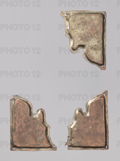 Three fragments of a Gospel book cover: two depict St. Mark and one St. Luke. Orthodox workshop. Luke the Evangelist; Mark the Evangelist d. ca. 68. Evangelists, icon covers, book iconography, inscriptions, saints. The plaques probably come from both sides of the binding. They depict: 1 Luke the Evangelist reaching for a pen; 2 Mark with an open book in his hands; 3 Mark sitting down to write with a pen in his hand. 17th–18th century, Russia. Cover. Height 9.4 cm; width 6.7 cm., A group of three irregular metal plaques displayed against a light gray background, each plaque showing worn engraved figures and decorative bordering; the plaques have a mix of coppery brown and greenish patina with darker and lighter variations, and show areas of tarnish and surface abrasion, with small holes near the edges and chipped or missing sections along their contours; the top plaque is positioned near the upper right and has a curved decorative lower edge, while the two lower plaques sit side by side...