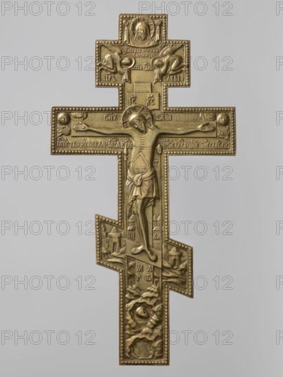 Cross: Crucifixion of Christ, Old Believers workshop; crosses; Jesus Christ Bible; angels; skull iconography; Adam Bible; Crucifixion iconography; moon iconography; sun iconography; instruments of the Passion of the Lord iconography; Jerusalem Israel/Palestine; Mandylion iconography; Golgotha iconography; Old Believers; inscriptions. The obverse shows Christ crucified on Golgotha. Below the cross in the grotto are shown Adam's skull and the tree of Seth; at the level of the footstool is a view of Jerusalem; on the crossbar are symbols of the sun and moon, and in the upper part above the cross the Mandylion and two angels descending towards Christ. The relief is decorative, very carefully crafted. The set of inscriptions and the font are typical of Bezpopovtsy Old Believer crosses. On the reverse there is an engraved plant ornament typical of the Pomeranian environment. 19th century, Northern Russia. Cross, height 38.5 cm, width 20.2 cm., A metallic cross-shaped plaque with a raised cen...