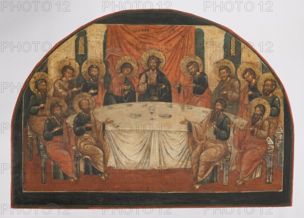 Icon: Last Supper, Russian workshop. The Last Supper iconography; Jesus Christ; Judas; Peter the Apostle; apostles; John the Theologian; John the Evangelist — iconography; icons; iconostases; chalices; halo; inscriptions; poteirons. The image is closed at the top by a full arch. It shows Christ and the apostles seated around a table. Christ blesses while the apostles on either side of the Savior raise their hands in prayer. Judas holds a purse. The table is covered with a cloth with abundant folds, depicting a chalice with two discs in the center and plates standing before the figures. In the background is a somewhat schematic interior with pillars and windows. The icon was probably originally part of an iconostasis. Its iconography and artistic form are influenced by Western tradition. 18th century, Volga; icon; height 44.8 cm, width 62.0 cm, depth 5.0 cm., A painted scene shows a group of people seated around a large table covered with a draped cloth, with a central figure behind the...