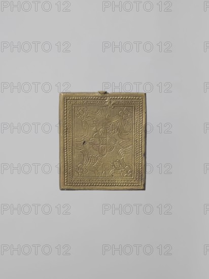 Icon: Our Lady of Tikhvin, Old Believers workshop, Our Lady of Tikhvin iconography, Mary mother of Jesus Christ, Jesus Christ Bible, icons, ornaments, Our Lady and Child iconography, maphorion iconography, inscriptions, unknown provenance. The icon represents a canonical variant of the Tikhvin image. The depiction of the figures, especially their faces, is somewhat archaizing. In the background of the image of the Mother of God with the Savior on her left shoulder, a schematic geometric pattern is marked. Inscriptions: MP OY, IC XC. On the reverse — a stylized floral-geometric ornament. 18th century, Russia. Height 5.8 cm, width 5.2 cm., A small rectangular ornate box in a metallic gold color is centered against a plain light gray background; the box surface has an embossed decorative pattern with floral and curving motifs framed by a textured border, and the edges of the box show slightly darker golden tones and minor wear.