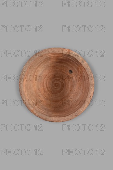 Fragment of a lydion. Archaic period. Fragmentarily preserved lydion foot and lower part of the body. The foot is flat, disc-shaped, conically recessed at the bottom in the middle. The medium-high, cylindrical foot tapers slightly towards the bowl. The preserved part of the bowl is hemispherical. The top of the foot, the foot, and the upper parts of the bowl are covered with a glossy varnish; the remaining parts are clay-colored. The outer surface of the bowl is decorated with four horizontally arranged thin lines in light brown. The interior of the bowl is not smoothed, with visible traces of turning. The outer part of the foot is covered with matte varnish. Varnish color 10 YR 2/1 black. Ornament color 2.5 YR 4/3 reddish brown; 2.5 YR 4/6 red. Color of clay 5 YR 6/6 reddish yellow. Dated on stylistic analogy to the 2nd half of the 6th century BC mid–late 6th century BC; analogies suggest c. 550–525 BC. Probable origin: Asia Minor Lydia or nearby eastern Greek regions. Type: vessel, l...