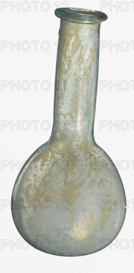 Pear-shaped vial, unknown Eastern workshop. The body is a slightly elongated sphere with a flattened bottom. The neck is long, exceeding the height of the body, cylindrical, ending with an outwardly curled horizontal rim. The surface on both sides of the joint between the body and the neck is decorated with a thin, grooved spiral line. 1st–2nd century, Roman Empire 27 BC–476. Vessel; height 17.5 cm, width 8.5 cm., A single glass bottle with a rounded base and a long narrow neck, shown upright against a plain background; the bottle surface has an aged, weathered appearance with irregular patches and streaks of a pale gold-beige color over a translucent bluish-green glass, and the rim at the top shows a slightly darker bluish-green tint.