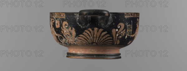 Red-figure bowl with Eros and a young woman, /workshop, red-figure pottery, bowl kylix, yellow clay tending to red, glossy black engobe, some elements painted white. Bowl with a ring-shaped base with two vices attached to the rim horizontally; palmettes beneath the vices. Belly decorated with two scenes: Scene A — young woman semi-reclining on the ground, facing left, holding a wreath in her left hand and a woven basket on her outstretched right hand; dressed in a long smooth chiton; wearing a pearl necklace and double bracelets on the wrists; hair tied in a bun with a kekryphalos. Scene B — Eros flying, facing left; in the right hand a musical instrument and in the left a wreath with a ribbon; hairstyle and jewelry match Scene A bun with kekryphalos, double bracelets, pearl necklace; additionally ankles adorned with bracelets and head with a diadem; entire figure shows hermaphrodite features. Condition: numerous chips, engobe dull in places. 3rd quarter of the 4th century BC, Apulia o...