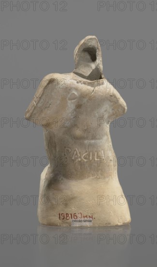Terracotta gladiator figurine, unknown Southern Italian workshop; terracotta male figurine. Figure of a gladiator ready for battle on a high base. Legs wide apart, left leg bent, right leg straight. On the calves are greaves reaching above the knees. In his right, bent hand he holds a dagger, and in the other a four-sided shield. He is dressed in a short draped tunic and wears a helmet. The Latin inscription PACILI is visible on the reverse of the base. Preservation condition: part of the base filled with plaster, partial shield and back of the head broken off, reflections, cracks. Date: 2nd–1st century BC, Southern Italy. Height 13 cm, width 7 cm., A worn pale beige sculpted torso on a neutral gray background, showing the upper body and partial neck with a hollowed head area and ragged edges where arms would be, surface texture varying between smoother and rougher patches with some darker beige and light brown discoloration, and a few small chips and cracks visible along the shoulders...