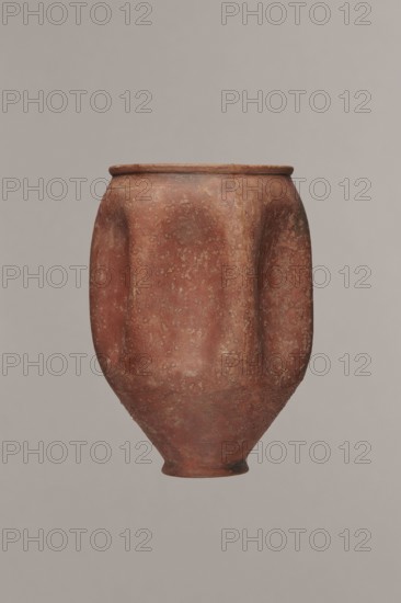 Rippled beaker miniature version, unknown Germanic workshop from Cologne?, hard-fired clay, fine-grained, with a small content of silvery mica, buff-pink-brown 5YR 6/4–6/6; grey-olive glaze 5YR 4/1–4/2, matte, covering the entire surface, exterior intentionally sandblasted and slightly rough; glaze discolorations above the foot from fingerprints. Walls of the vessel have six decorative dents. Minor damage to the rim and slight cracks. 2nd half of the 2nd–3rd century; probably Cologne; vessel, height 9.7 cm, diameter 5.5 cm., A single large rounded clay vessel with an uneven surface and a narrow foot, displaying a mottled reddish-brown color with patches of lighter beige and darker brown, set against a plain light gray background.