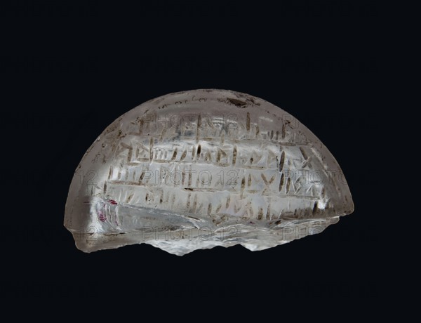 Fragment of an amulet with an Arabic inscription, message provenance, Islamic art, Arabic culture, amulets, inscriptions, Arabic language, inscription probably with magical meaning, 11th–12th century, Egypt, amulet, height 1.1 cm, width 2.5 cm, depth 0.9 cm, A translucent, dome-shaped object with a smooth curved top and an irregular jagged bottom edge sits against a dark black background, showing a clear to milky white appearance with areas of pale brownish and grayish inclusions and surface marks, and a small patch of muted red near one edge; the surface bears shallow linear grooves and scratches arranged in horizontal groupings and vertical strokes, and light reflects off glossy and slightly frosted areas creating subtle highlights and shadows.