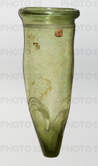 Lamp oil container, deposit provenance, Islamic art, Arabic culture, glass oil lamp, cream enamel thread also at the bottom, 12th–15th century, Syria, Egypt, Middle East, height 12.0 cm, diameter 5.2 cm, A translucent green glass vessel with a rounded flaring rim and a tapered pointed base, showing many small bubbles and some irregular cloudy patches inside the glass; the upper shoulder has a subtle horizontal ridge and the lower body features applied raised curving lines forming looped wave-like decorations; colors visible include shades of green, pale yellow-green, and small areas of brownish discoloration on the surface.