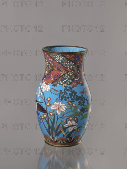 Vase, doves, flowers iconography, Japanese art, Japanese culture, Choynowski, Józef 1833-ca 1915, birds, Meiji 1868-1912, peonies, chrysanthemums, wolfberries, kachôga iconography, sakura iconography, cloisonné enamel. Belly flowing smoothly into a short, thick, slightly parted neck. Cloisonné enamel on copper; brass foot and spout frame, ca. 1870–1880 Meiji Period, 1868–1912, Nagoya, Japan. Vessel; height 26.5 cm, width 12.6 cm., A single decorative vase with a flared rim sits against a plain gray background, the vase showing a bright sky-blue main field with a band of darker patterned decoration near the top; the surface is covered with floral and foliage motifs including lilies and other blossoms in colors such as pink, white, red, yellow, green, and blue, with black and dark green leaves and stems. The upper patterned band contains swirling designs in red, black, blue, white, and gold tones, and the rim and base edges are accented with a metallic bronze color. The vase rests on a r...
