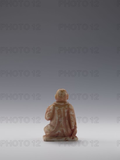 Sage, unknown sculptor; figurine of a bonza priest; 19th century, China Qing dynasty, 1644–1911; Chinese art; maker possibly Choynowski, Józef 1833–c.1915 or Dawidow, Alexander Petrovich 1838–1885 attributions uncertain; sculpture; height 10.4 cm, width 6.9 cm, depth 5.0 cm., A small carved figure seen from behind, seated on a base with a rounded head and ears, wearing a draped robe with folds and a high collar, one arm bent with the hand near the chest and the other resting by the side; the surface shows a mottled pattern in shades of peach, pink, beige, and off-white against a neutral gradient background of gray transitioning to lighter gray toward the bottom.