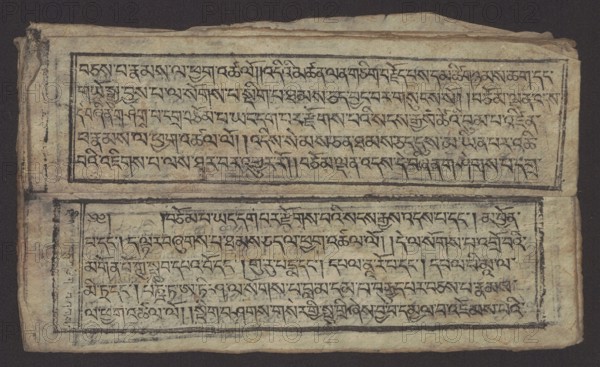 Buddhist text - Formula of repentance Tib. sdig bshags gser gyi spu gri bzhugs so, unknown author, Buddhist art, Tibetan culture, graphic prints, Book in the Tibetan pecha style, xylographic print in the disciple script dbu can, 16 folios, folio numbering 2-15 recto, first verso. Print on thin handmade paper, clear translucency. 19th century, Tibet. Graphic, width 25.5 cm, height 7.8 cm, An aged, rectangular sheet with a textured, yellowed surface rests against a dark background; the sheet shows two horizontal framed panels filled with dense, dark ink markings arranged in lines, with the ink appearing black and slightly faded in places, and the frames rendered in thicker black strokes. The paper edges are irregular and worn, with creases and small tears, and there are visible smudges and spots of darker discoloration along the margins. The overall color palette includes off-white, beige, tan, brown, black, and faint gray tones, and the composition shows a few areas where the ink is hea...