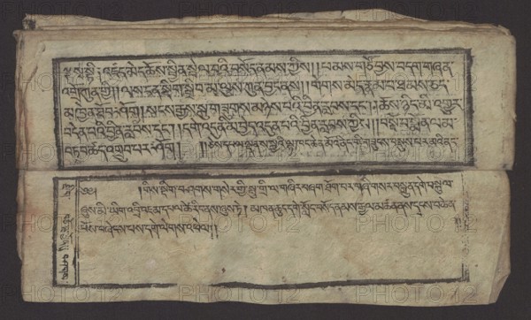 Buddhist text - Formula of repentance Tib. sdig bshags gser gyi spu gri bzhugs so, unknown author, Buddhist art, Tibetan, graphic prints, Book in the Tibetan pecha style, xylographic print in the disciple script dbu can, 16 folios, folio numbering 2-15 recto, first verso. Print on thin handmade paper, clear translucency. 19th century, Tibet. Graphic. Width 25.5 cm, height 7.8 cm., A worn rectangular sheet with a dark background shows a pair of horizontal panels separated by a fold; the upper panel contains a framed, textured area with dense dark markings and a thick dark border, while the lower panel has a similar framed area with lighter markings and more open space, plus a narrow vertical margin panel at the left with dark markings; the paper appears aged with creases, rough edges, small stains, and slightly torn corners, exhibiting colors of beige, off-white, tan, black, dark brown, and hints of reddish-brown.