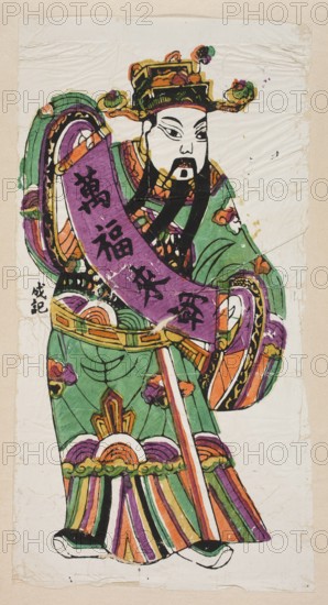 Menshen Gate Guardian, unknown artist, nianhua New Year’s picture, early 20th century, Fengxiang; graphic print woodblock, depicted as a dignitary holding an inscribed scroll; Chinese art—guards; height 44.0 cm, width 23.5 cm., A standing figure wearing an ornate hat and long flowing robes fills the image, rendered in bright colors including green, purple, orange, black, white, and touches of yellow and pink. The figure has a pale face with stylized facial features and a black beard and moustache, and a colorful headdress with decorative round elements. A broad sash or banner in purple drapes across the torso, and layered garments show patterned borders and curved motifs in green, orange, purple, yellow, and black. The sleeves and lower robe have multicolored striped sections and cloud- or floral-like decorations in orange, purple, and green. The background is a textured off-white paper with visible creases and worn edges.