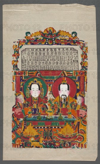 God of the Home Zaowang with his wife, nianhua New Year's picture, gods, Chinese art, Chinese culture, early 20th century, Yangliuqing, graphic print, height 39.2 cm, width 24.4 cm, A vertical image of a colorful painted print on pale beige paper showing a framed scene with two central seated figures with pale faces, dark hair, and ornamental headdresses, each within circular halos; they wear richly patterned robes in red, orange, green, and gold, and hold ceremonial objects on a decorated table in front of them. Surrounding the central pair are a group of attendants and smaller figures in similar colorful attire positioned on both sides and behind, all rendered with stylized facial features and flushed pale pink cheeks. The composition is enclosed by an ornate border and canopy featuring swirling floral and geometric motifs in bright colors including red, green, orange, yellow, purple, and teal, with gold-toned accents and dark outlines. The upper area above the seated figures contain...