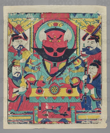 Fire-guarding deity, protective deities iconography, Chinese culture, nianhua, New Year's picture, deity in military official's costume with four acolytes, early 20th century, Beijing, graphic print, height 49.0 cm, width 42.0 cm, A colorful printed image shows a central large figure with a red face, white side hair, and bold black facial markings seated on a throne-like structure, wearing a blue and turquoise robe with yellow and red decorative elements; a few smaller robed figures flank the central figure on both sides, each holding different objects and wearing garments in shades of red, blue, turquoise, yellow, and green; the scene includes patterned banners and a decorative arch in turquoise, yellow, red, and blue above the central head, and ornamental designs such as floral motifs and stylized fish and bird imagery in red, blue, turquoise, yellow, and black near the lower area; the background paper has a pale off-white tone with visible creases and slightly worn edges.